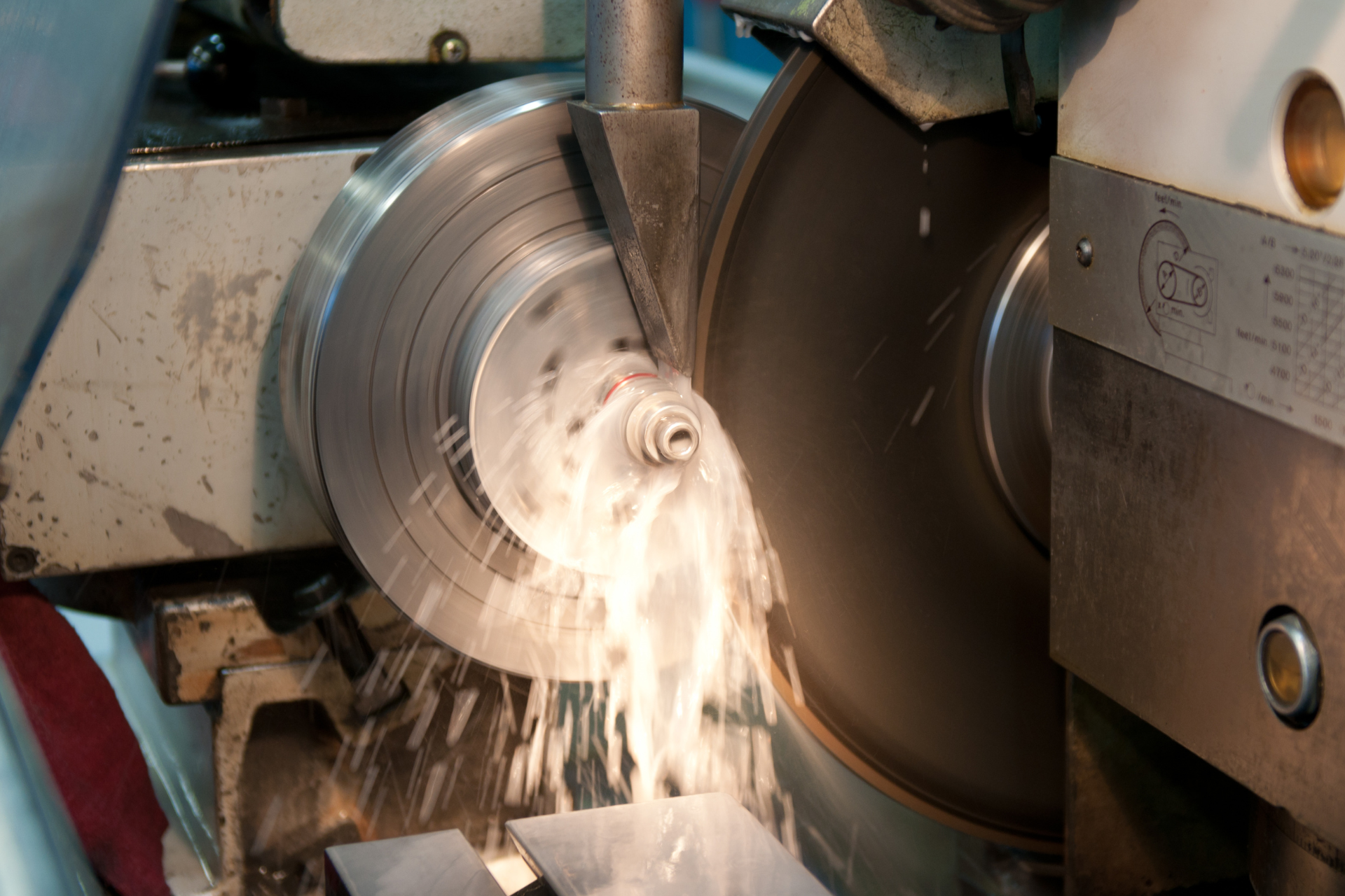 A machine is cutting a piece of metal with a circular saw.