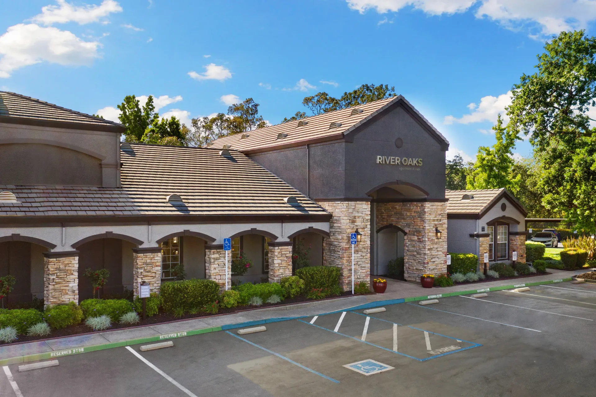 Exterior of Riverbend building with arched entrance and parking spaces.