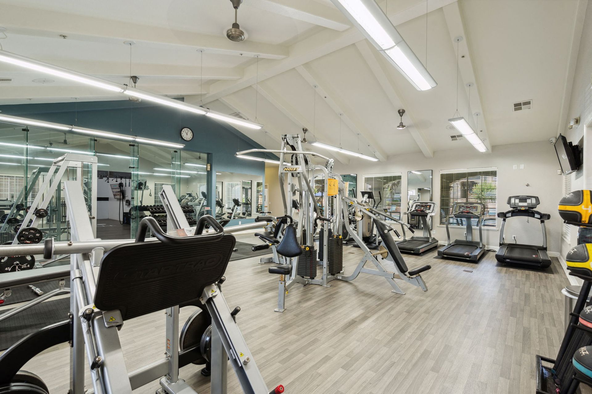 Interior view of a modern on-site apartment gym with cardio machines and weight equipment.