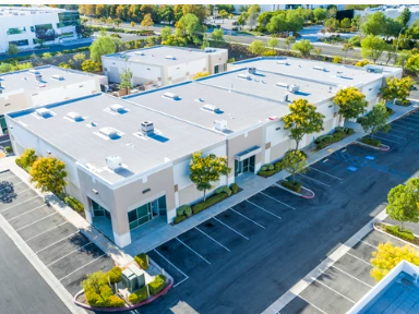 An aerial view of a large building with a parking lot in front of it.