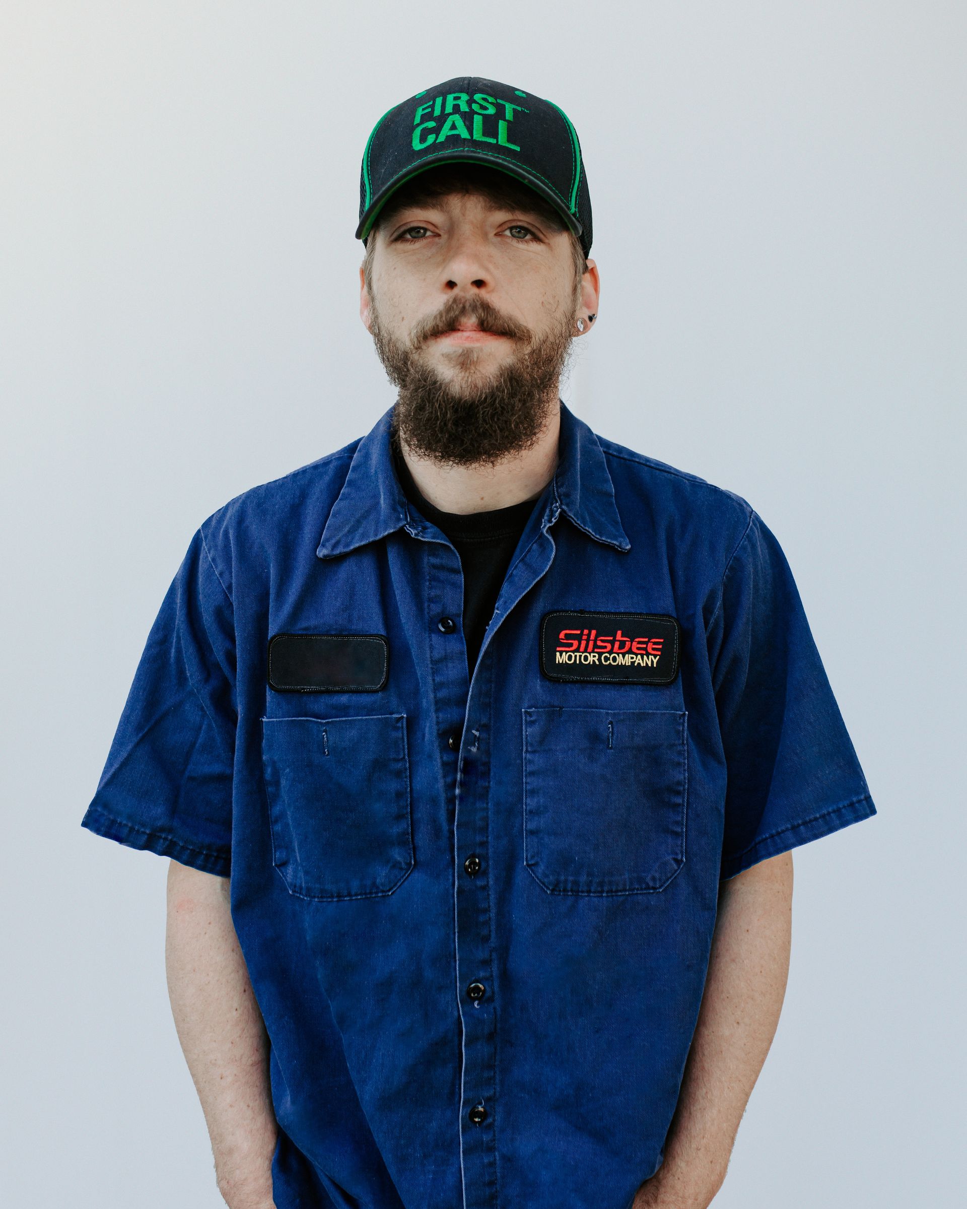 A man with a beard wearing a hat that says simply call