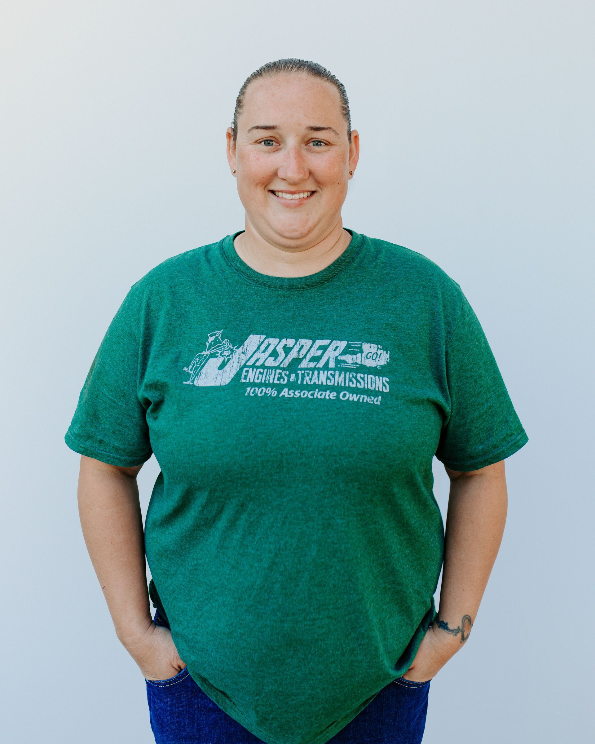 A woman wearing a green t-shirt with the word jasper on it