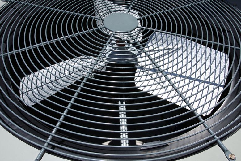 A close up of a fan with a metal grill on it