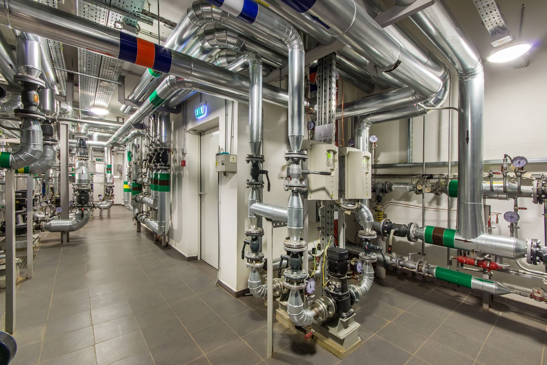 A room filled with lots of pipes and valves in a factory.