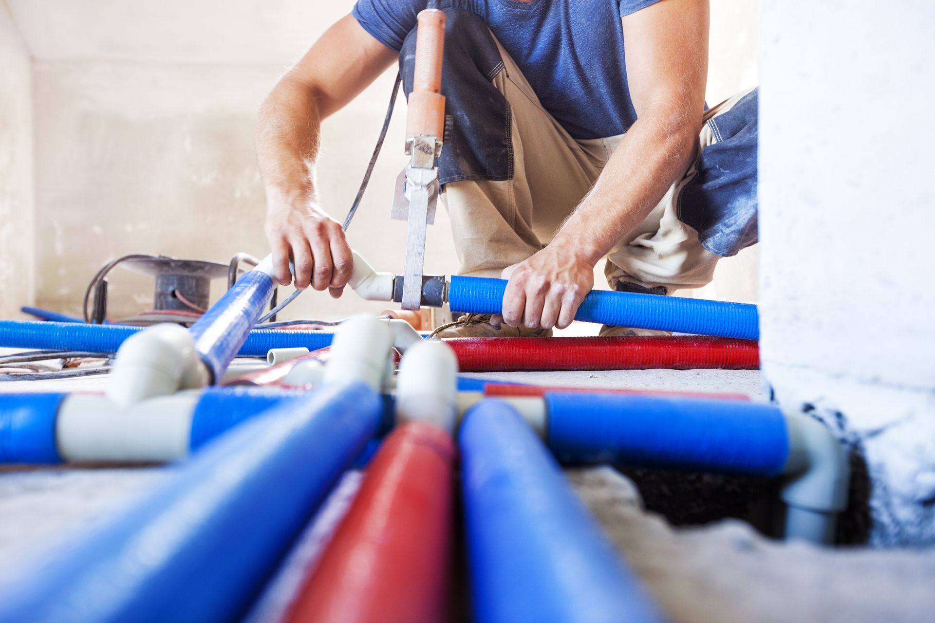 A man is working on a pipe system in a room.