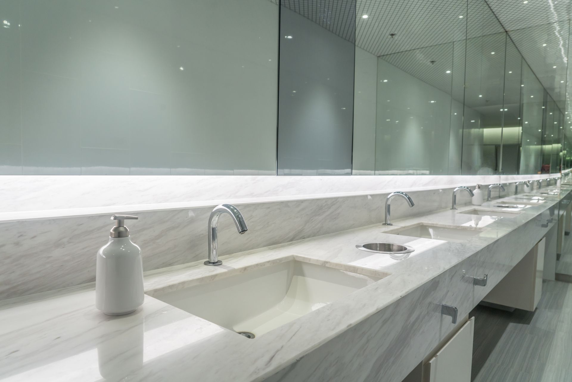 A bathroom with a lot of sinks and mirrors.