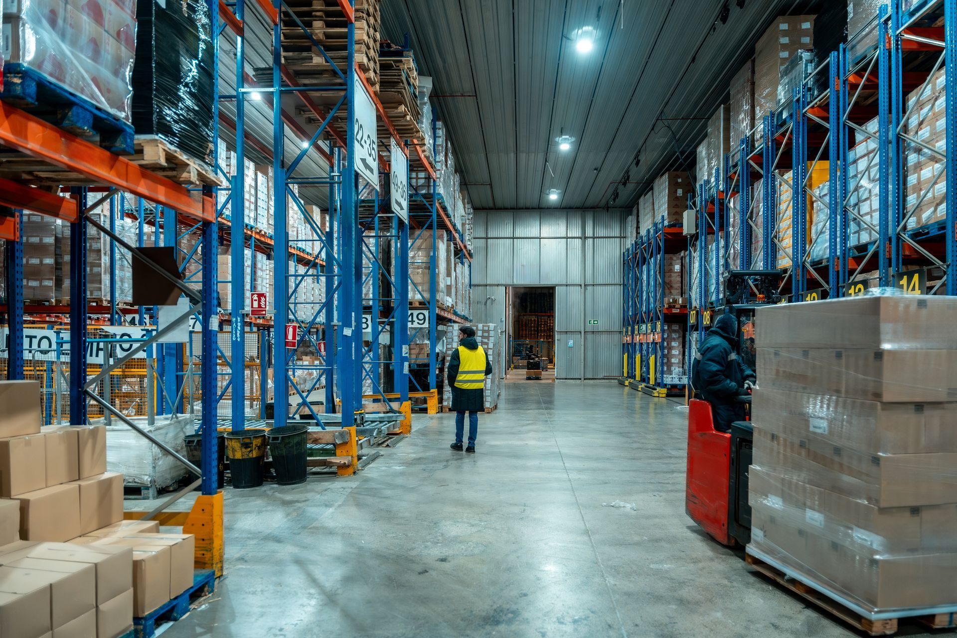 Bright hallway lined with closed white self-storage unit doors in a modern facility.