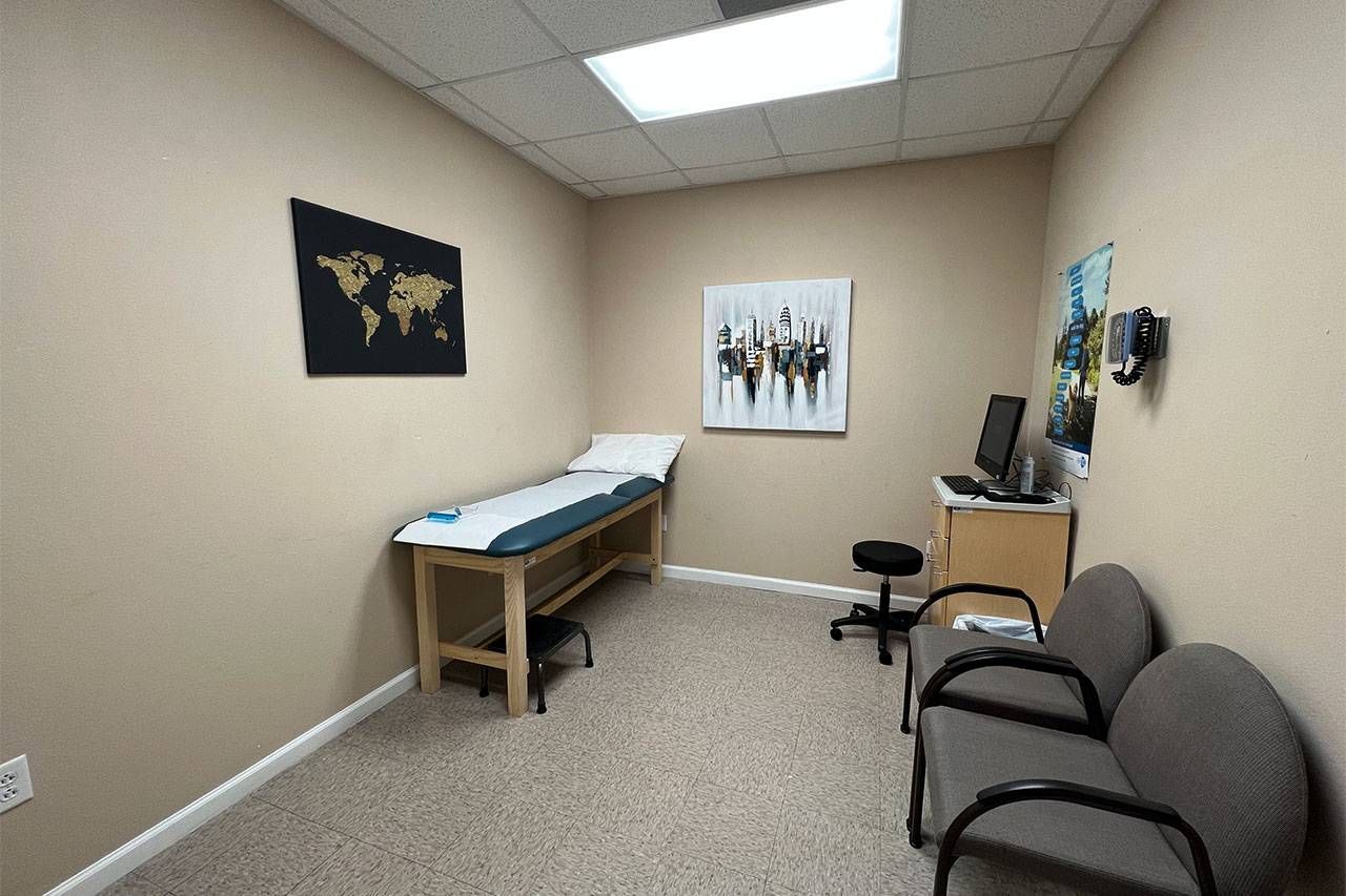 A doctor 's office with a table and chairs | Arkansas Spine and Pain