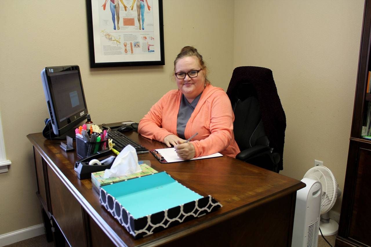 A woman is sitting at a desk in front of a computer | Arkansas Spine and Pain