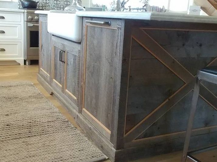 Rustic kitchen island with farmhouse sink and distressed wood paneling.