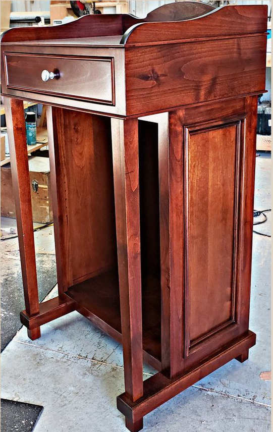 Wooden lectern with a drawer, open storage, and dark cherry finish.
