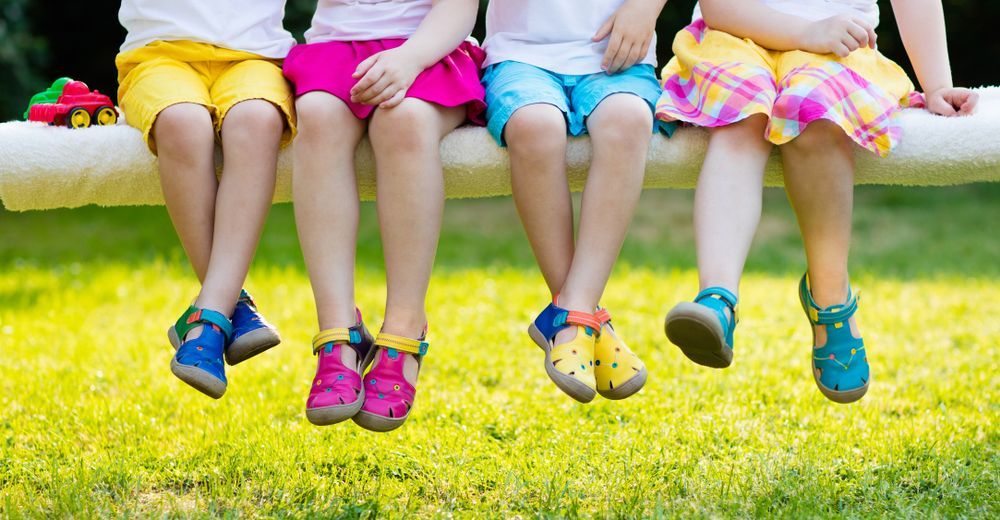 Four Children Sitting on a White Beam Legs Dangling — Five Star Family Day Care in Metford, NSW