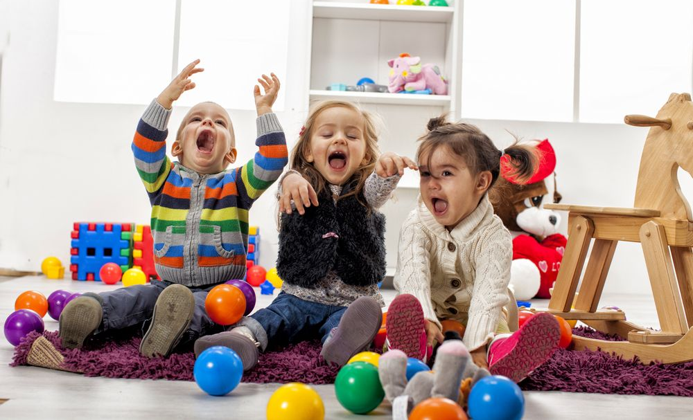 Three Children Laughing and Playing on a Purple Rug — Five Star Family Day Care In Metford, NSW