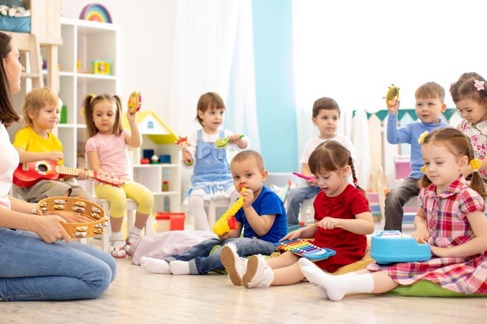 A Group of Children Are Sitting on the Floor Playing Musical Instruments — Five Star Family Day Care in Lake Macquarie, NSW