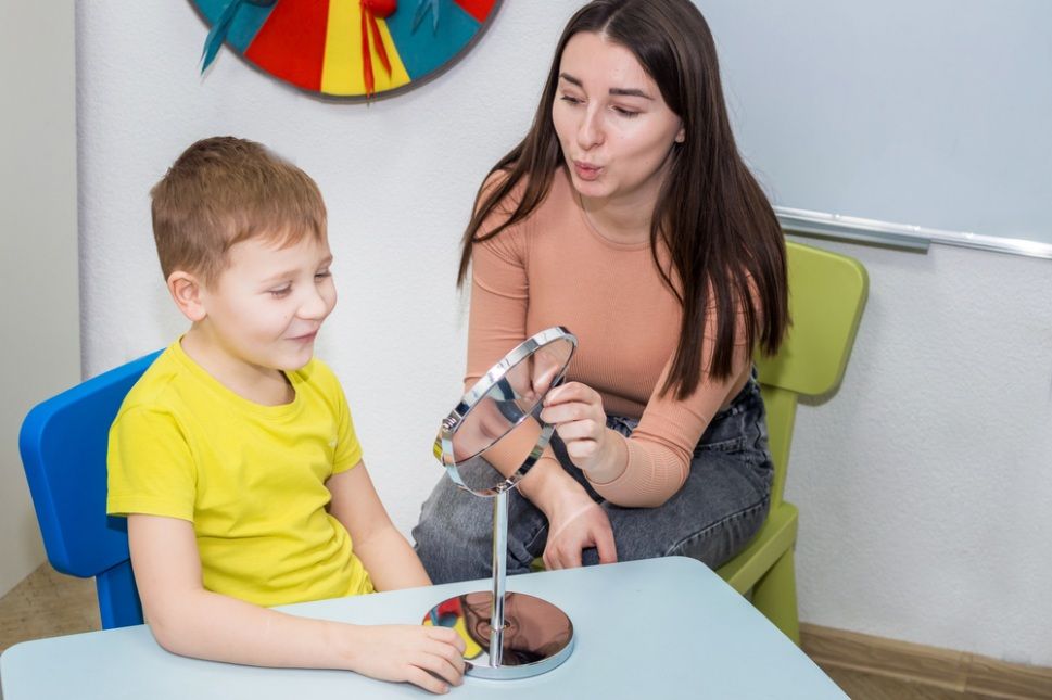 Woman Demonstrating Mouth Movements to a Boy Using a Mirror  — Five Star Family Day Care in Port Stephens, NSW