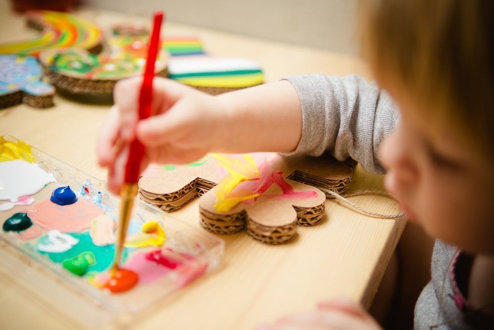 Child Painting Cardboard Shapes — Five Star Family Day Care in Metford, NSW