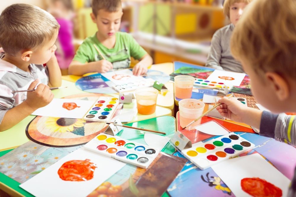 Children Painting With Watercolors at a Table in a Brightly Lit Classroom — Five Star Family Day Care in Metford, NSW