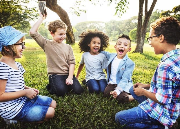 Group of Diverse Children Laughing and Playing on the Grass in a Park — Five Star Family Day Care in Metford, NSW