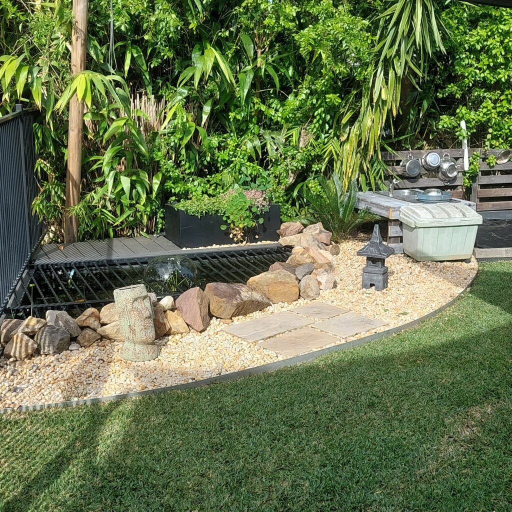 A Backyard Pond with Rocks, Plants, and A Small Stone Pagoda — Five Star Family Day Care in Maitland, NSW