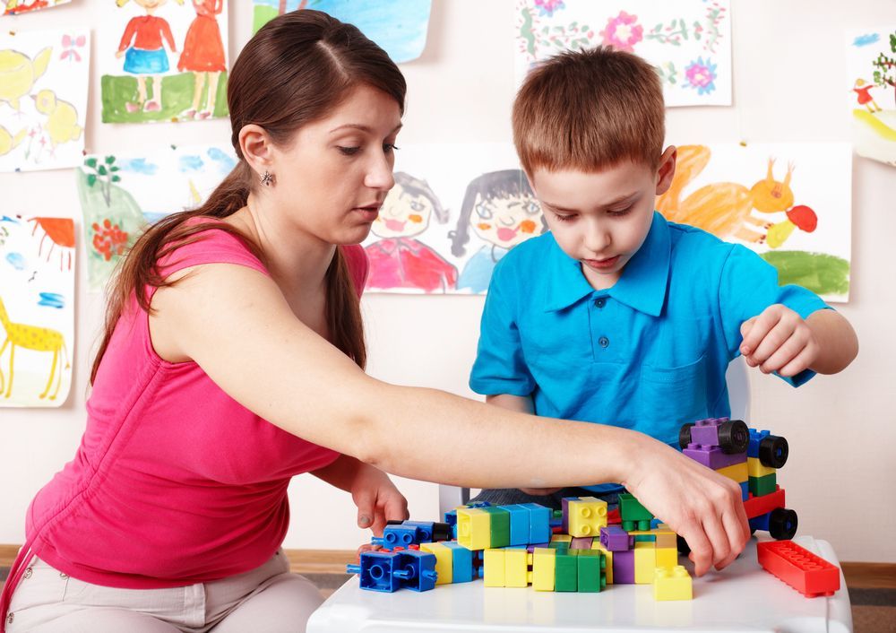 Woman and Child Playing with Colorful Blocks at A Table — Five Star Family Day Care in Newcastle, NSW