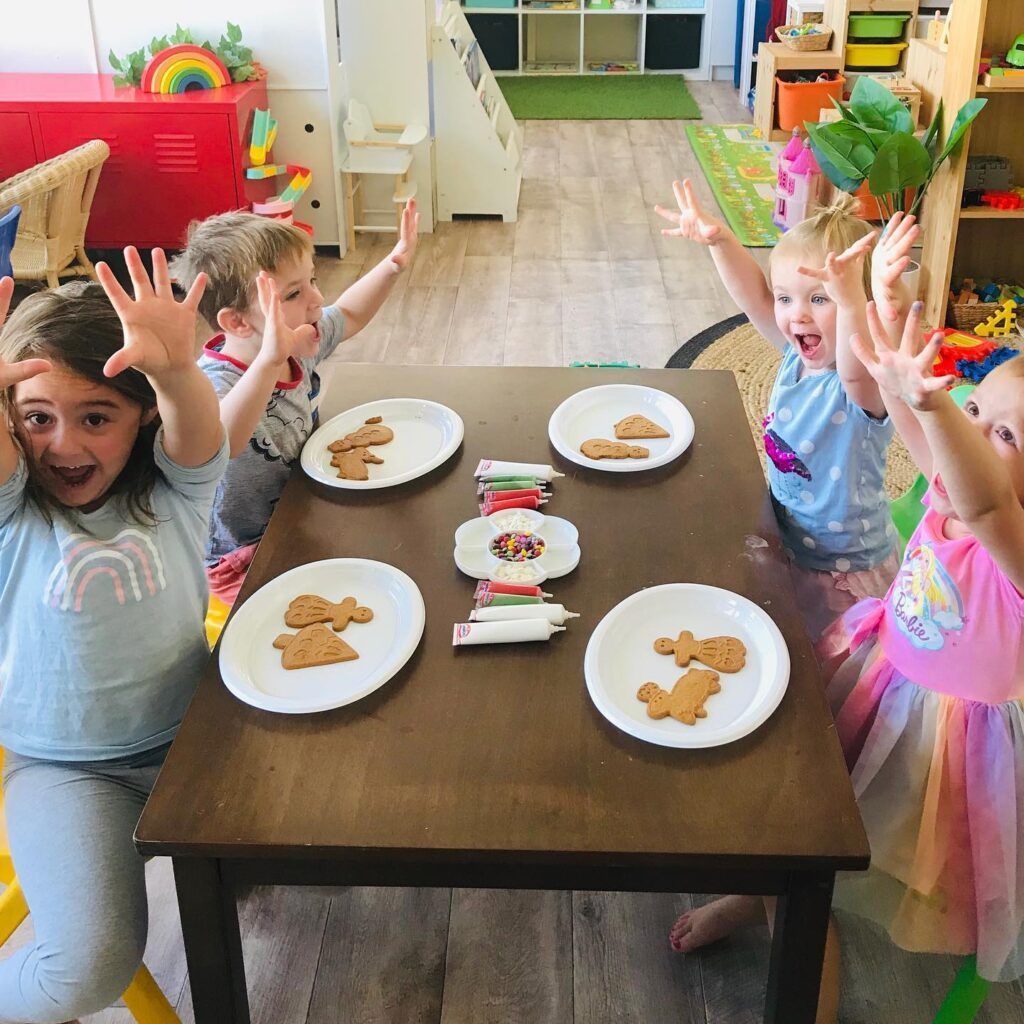A Group of Children Are Sitting at a Table With Plates of Cookies on It — Five Star Family Day Care in Maitland, NSW