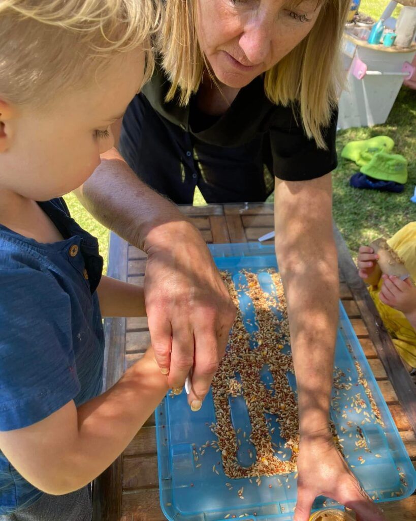 A Woman is Teaching a Young Boy How to Make a Bird Feeder — Five Star Family Day Care in Maitland, NSW