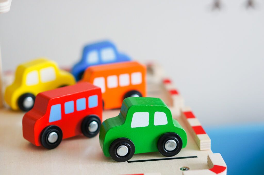 A Group of Wooden Toy Cars Are Sitting on Top of a Wooden Table — Five Star Family Day Care in Cessnock, NSW