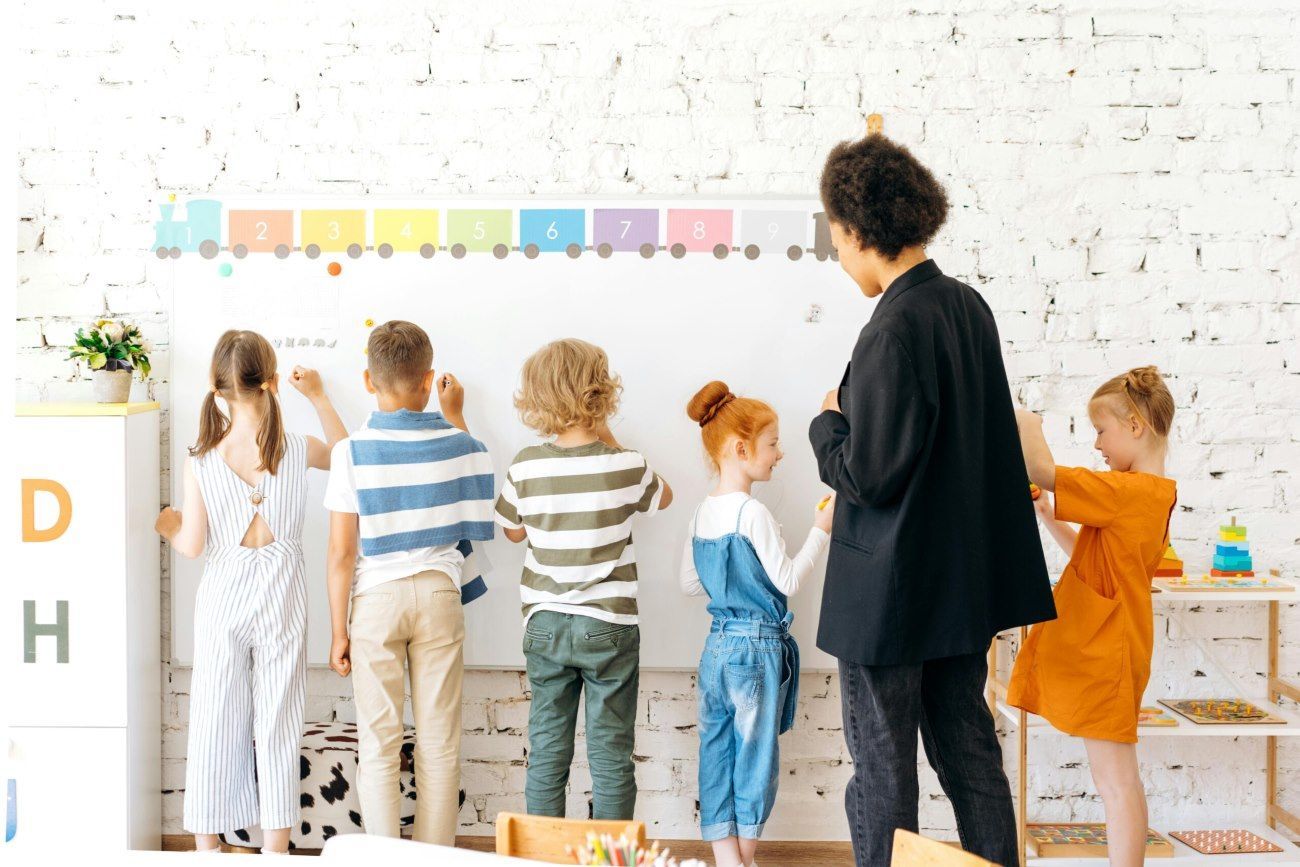 A Group Of Children Are Writing on the Whiteboard — Five Star Family Day Care in Maitland, NSW