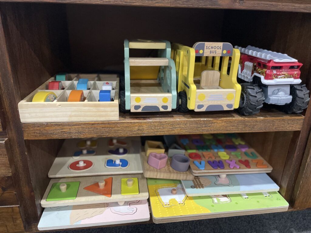 Wooden Toy Shelf With Vehicles, Puzzles, and Shape Sorters — Five Star Family Day Care In Muswellbrook, NSW