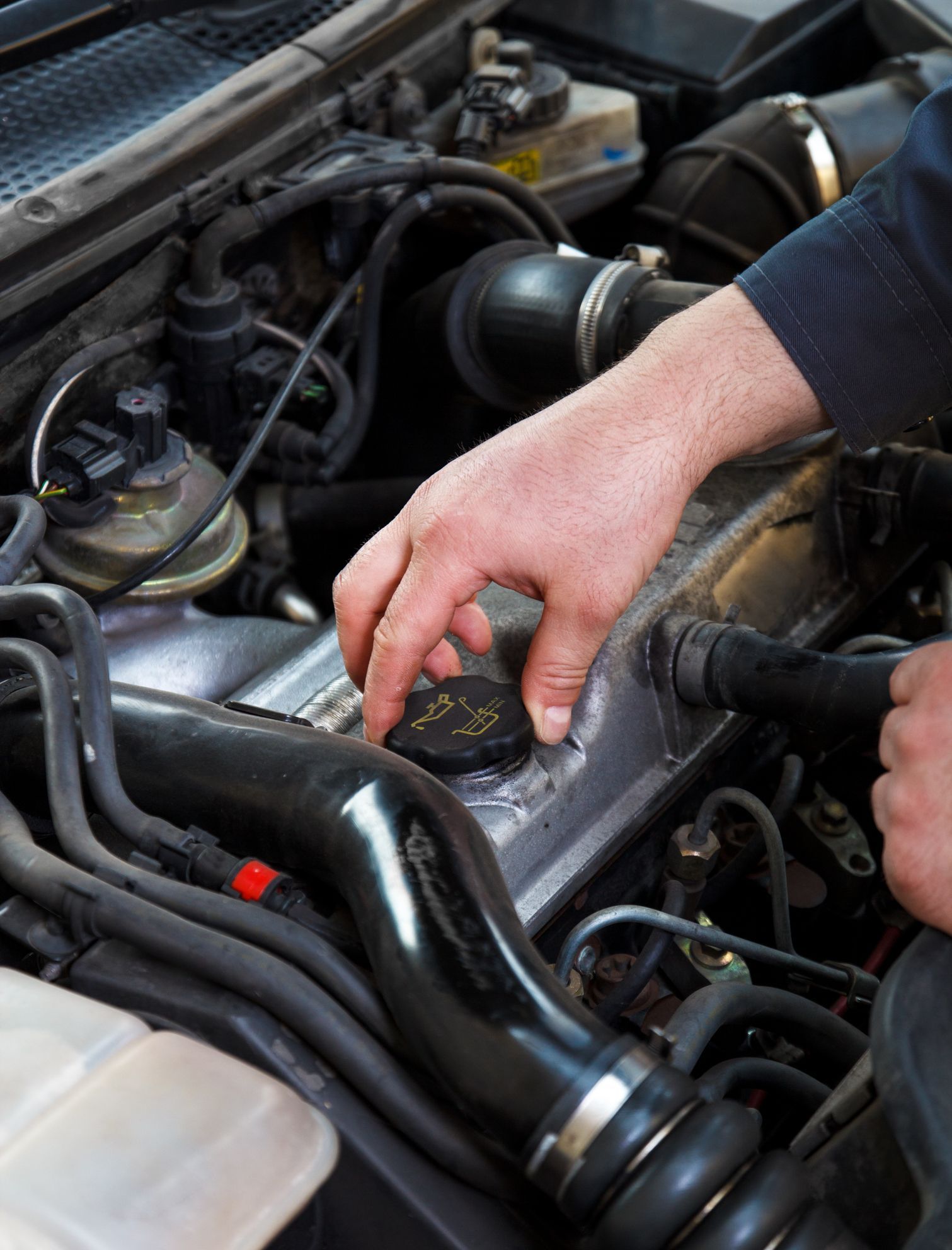 A man is working on the engine of a car. | Ruckersville, VA | KEL-CAM Tire & Auto
