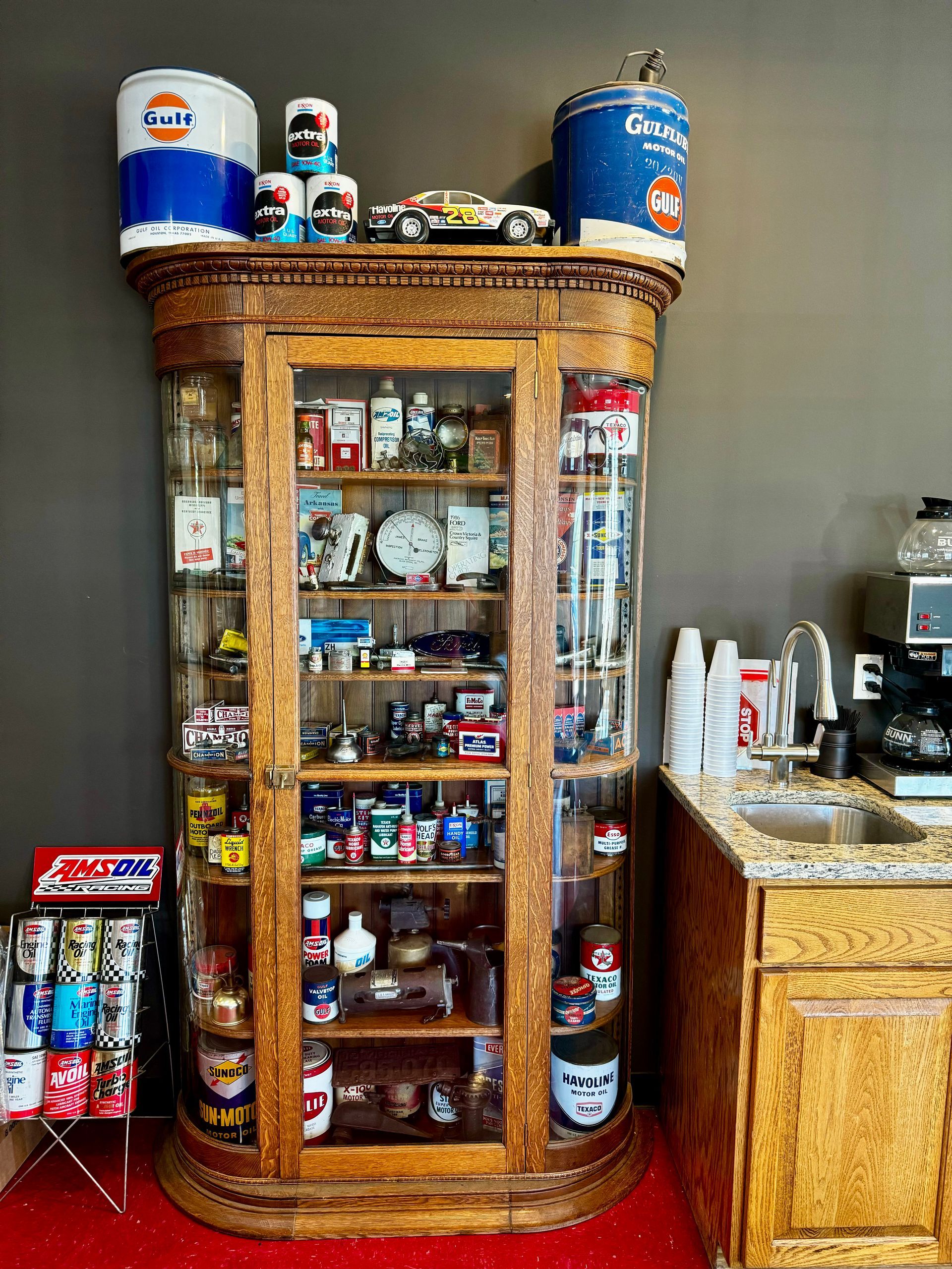 A large glass cabinet filled with lots of items in a kitchen.