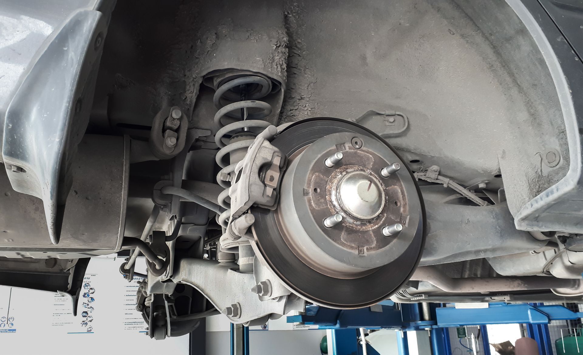 The rear wheel of a car is being repaired in a garage.| Ruckersville, VA | KEL-CAM Tire & Auto