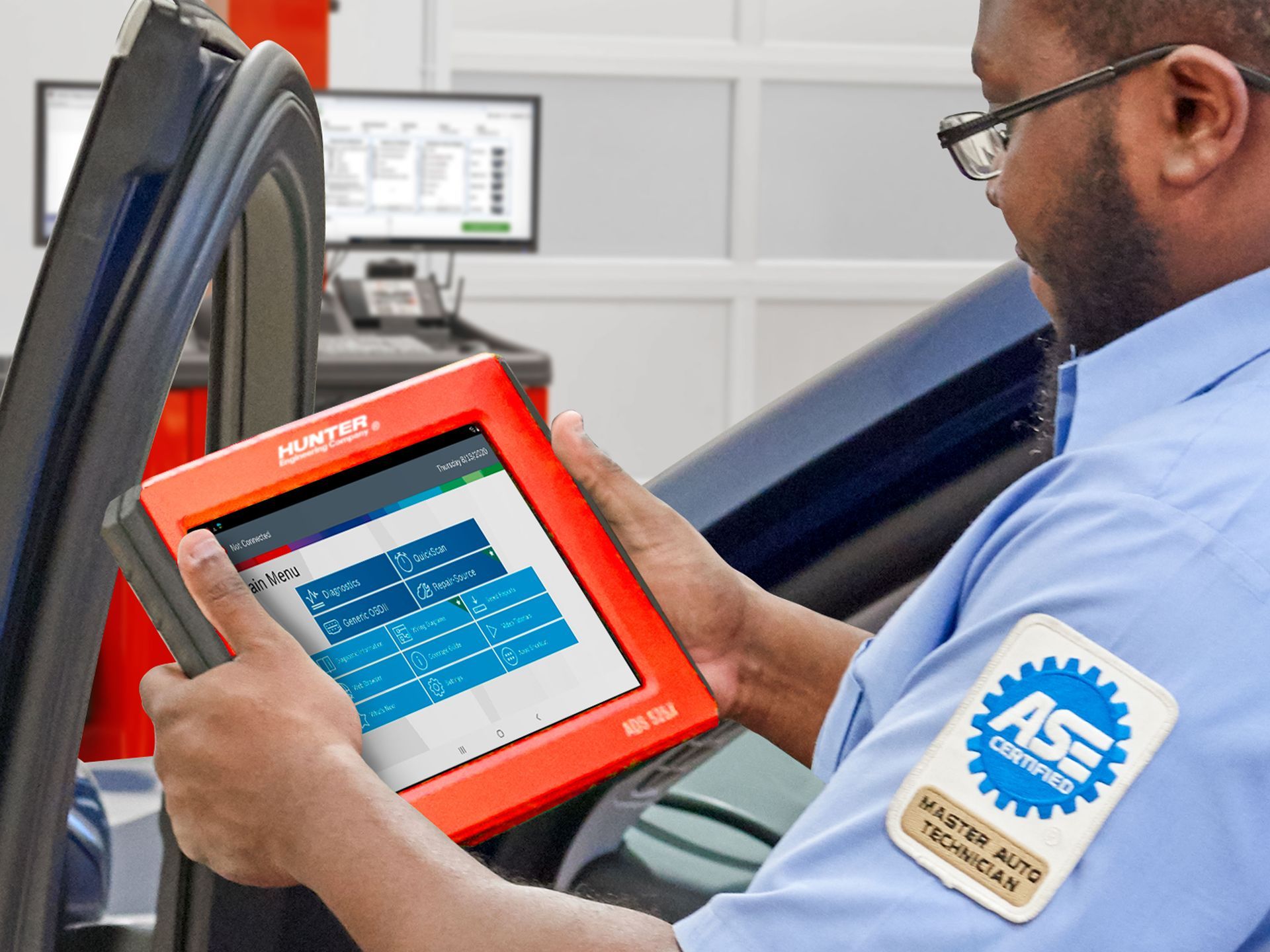 A man is holding a tablet in front of a car. | Ruckersville, VA | KEL-CAM Tire & Auto