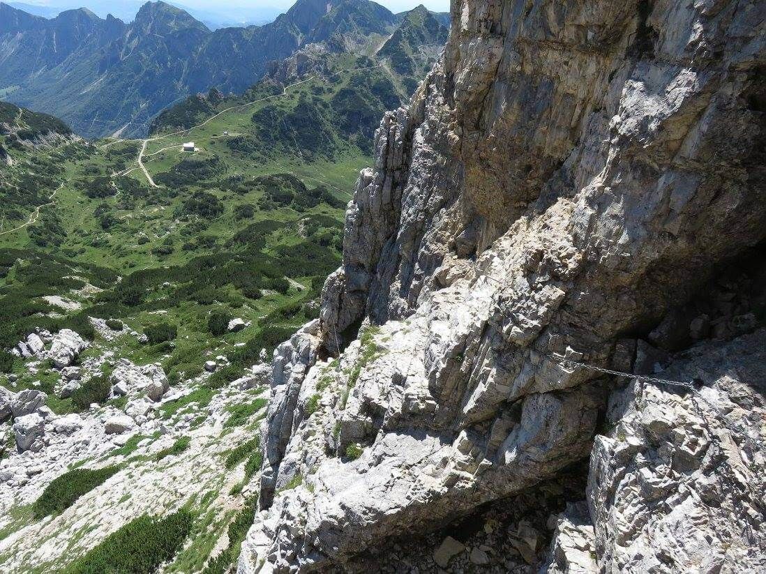 a view of a mountain valley from the top of a rocky cliff .