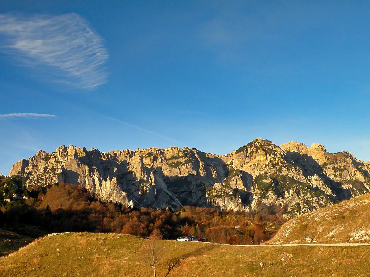 Una catena montuosa con un cielo azzurro e nuvole sullo sfondo