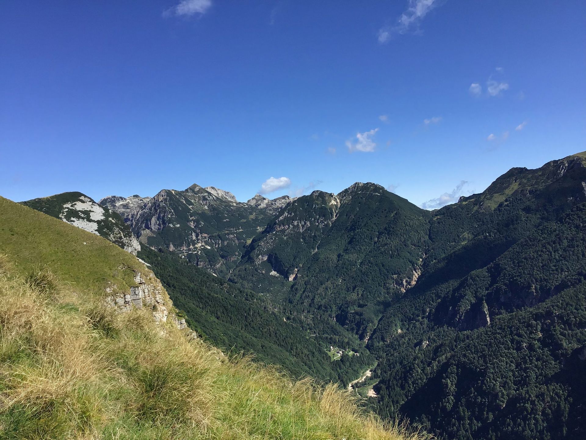 Una vista di una valle circondata da montagne in una giornata di sole
