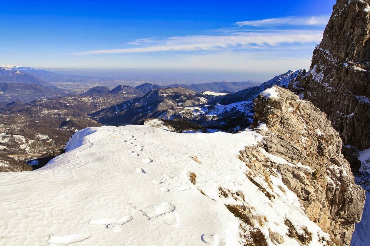 Ci sono impronte nella neve sul fianco di una montagna.