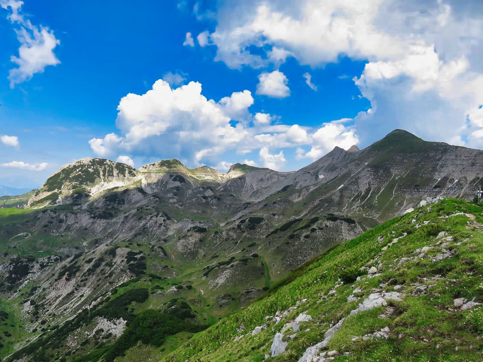 Una catena montuosa con un cielo azzurro e nuvole sullo sfondo