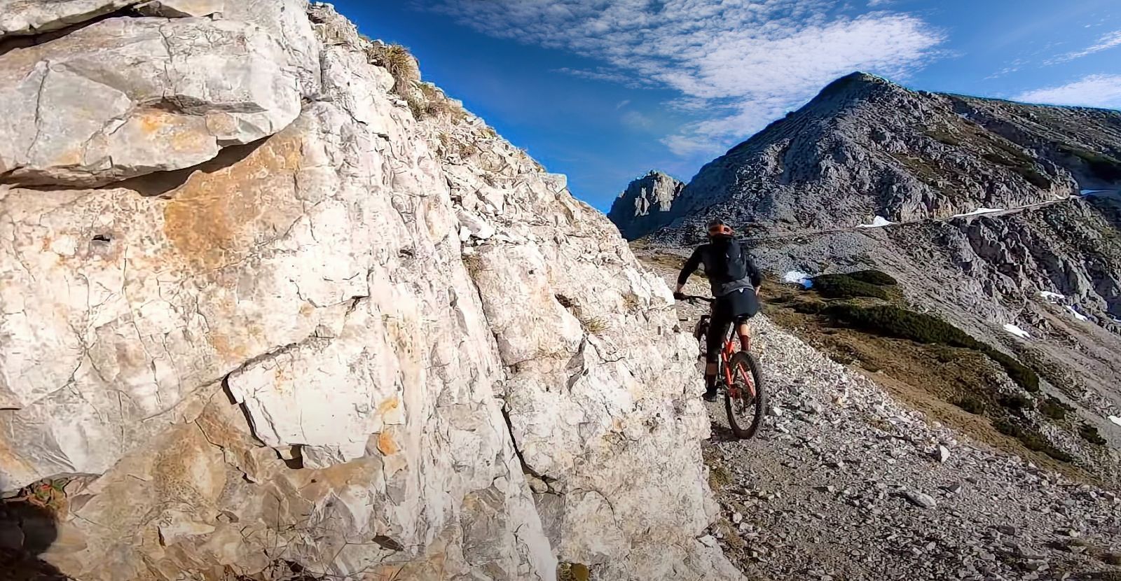 Una persona sta andando in bicicletta su un sentiero roccioso in montagna.