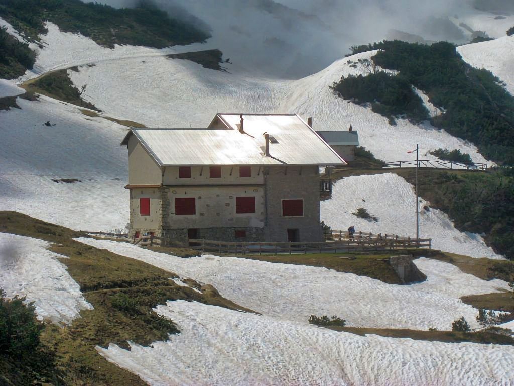 Una casa si trova in cima ad una collina coperta di neve