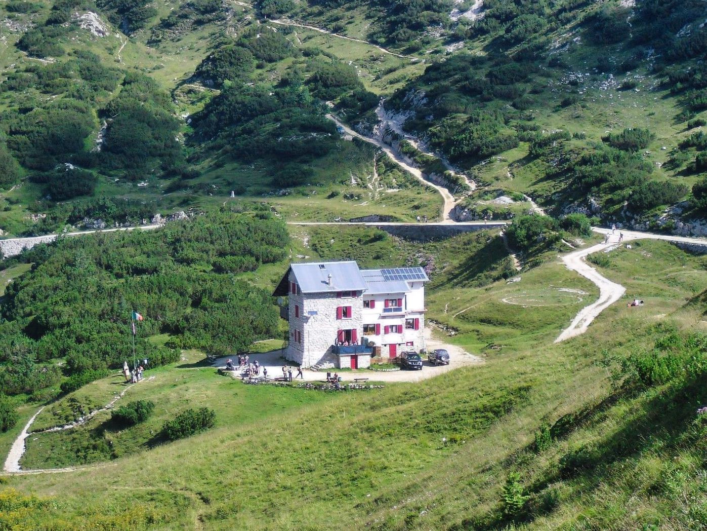 Una casa nel mezzo di una collina verde lussureggiante