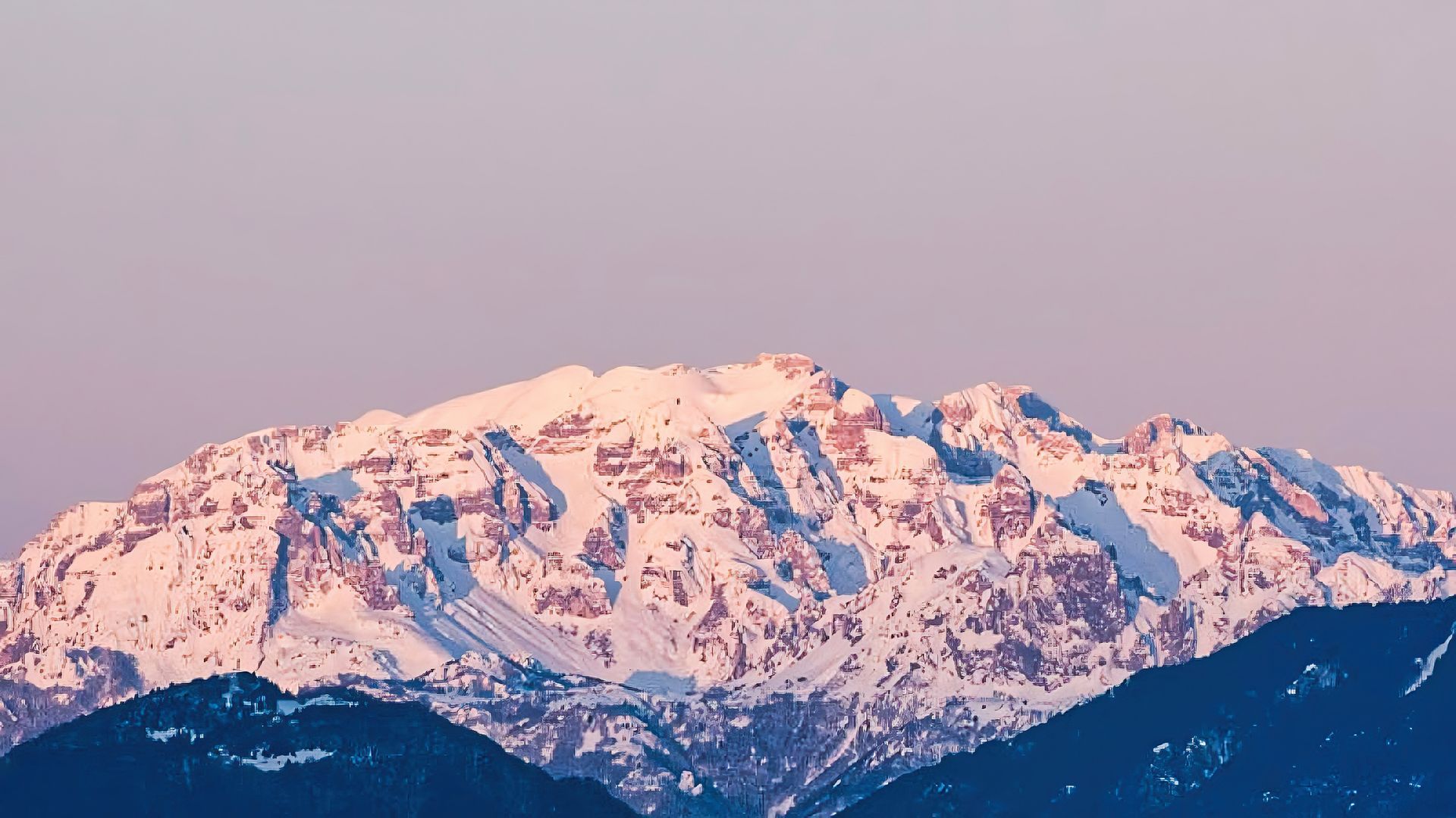 Una montagna innevata con un cielo azzurro sullo sfondo
