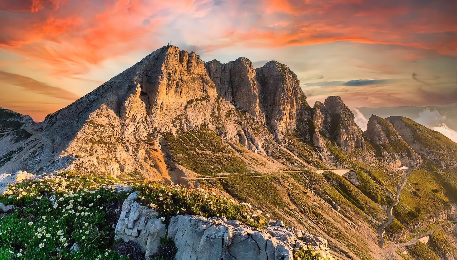 Sullo sfondo c'è una montagna con un tramonto nel cielo.