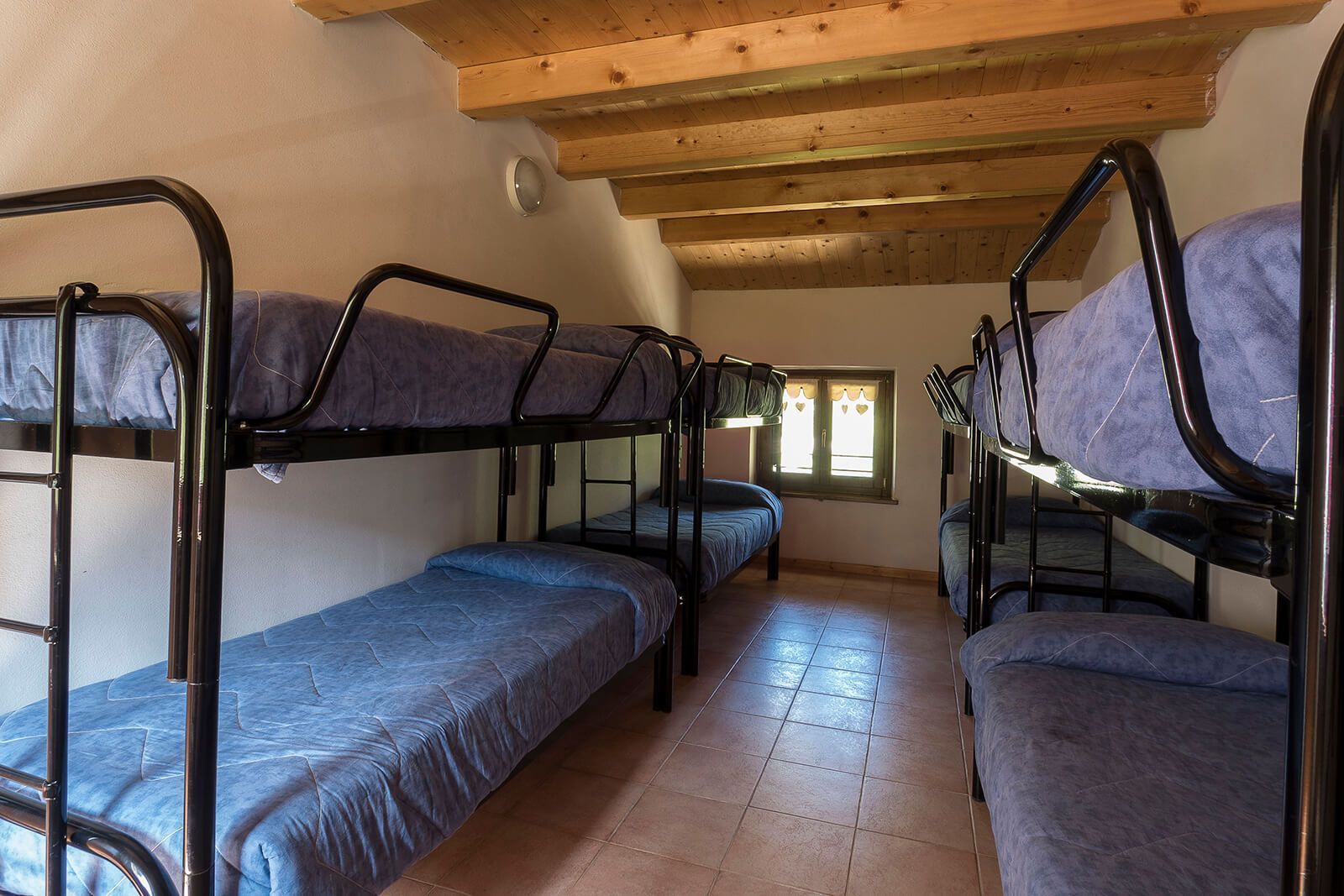Una stanza piena di letti a castello e una finestra
