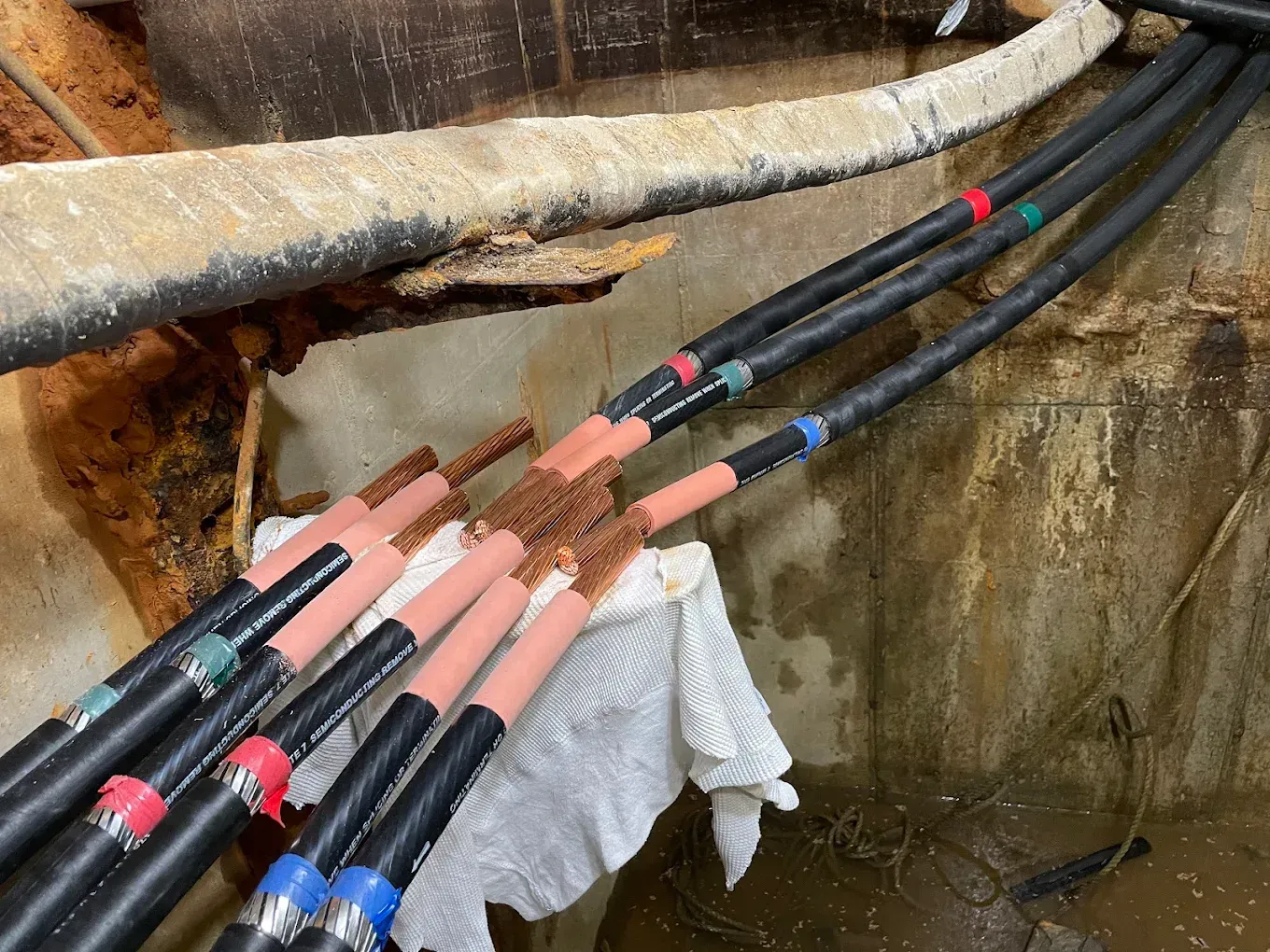 Electrical cables with colored heat shrink tubing, in a damp industrial setting.