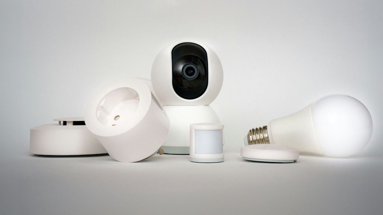 Smart home devices: security camera, outlet, light bulb, motion sensor, and smoke detector.