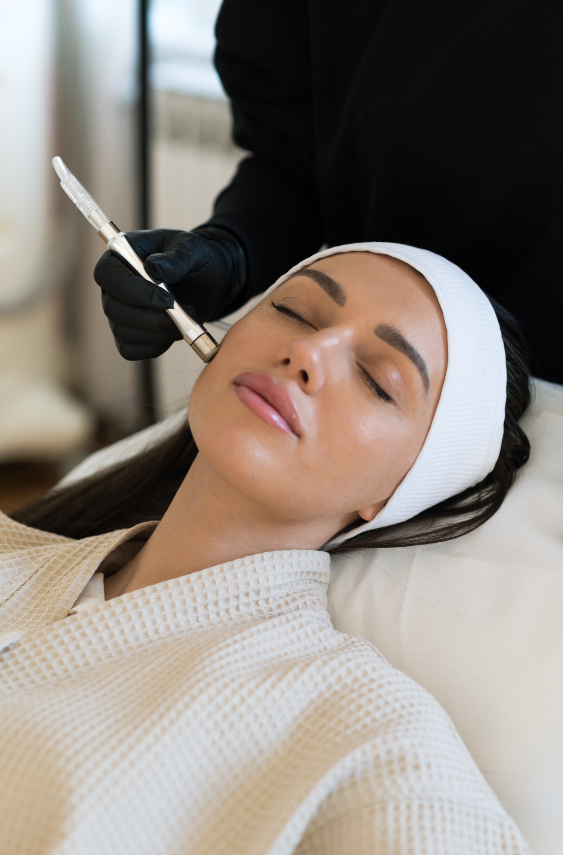 A woman is getting a botox injection in her forehead.
