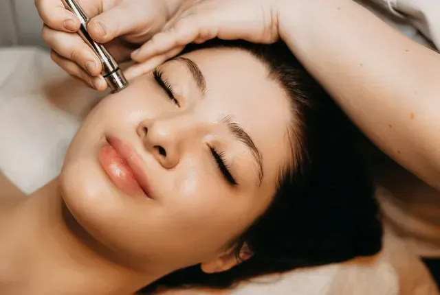 A woman is getting a facial treatment at a beauty salon.