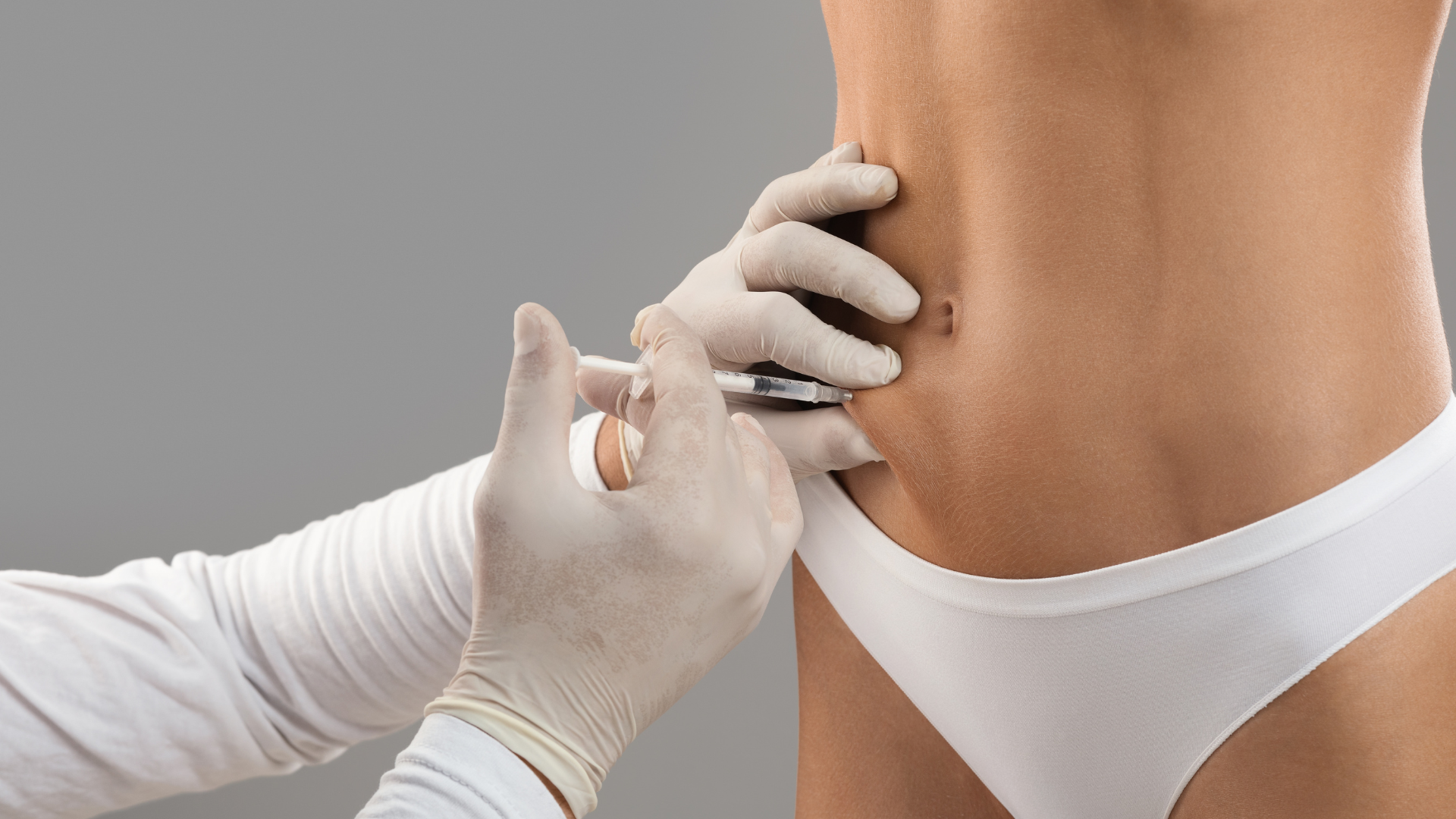 A woman is getting an injection in her stomach.