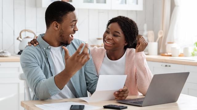 happy couple holding a tax refund check